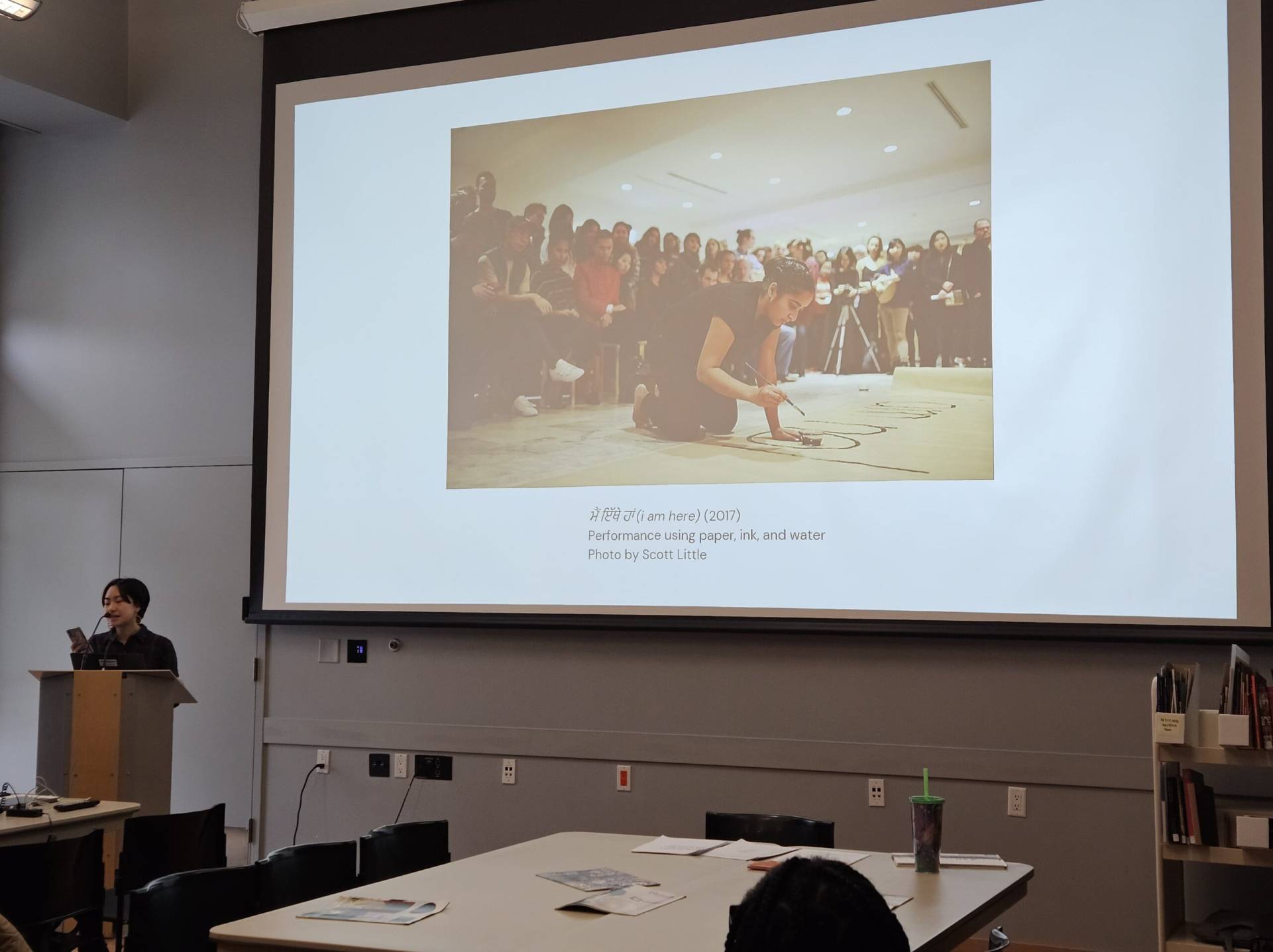 Performance art with paper ink and water in a gallery setting, captured during a live art performance.